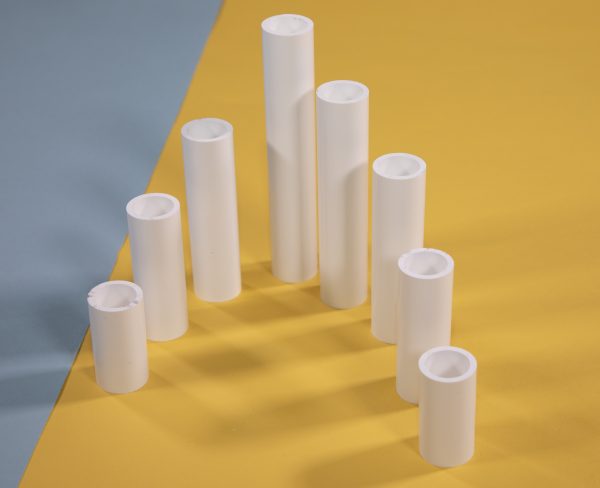 A set of weight plastic cylinders in various heights arranged in a v-shape formation on a yellow and blue background.