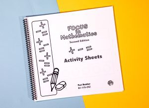 FOCUS in Math spiral-bound activity sheets workbook sitting on a yellow and blue background.