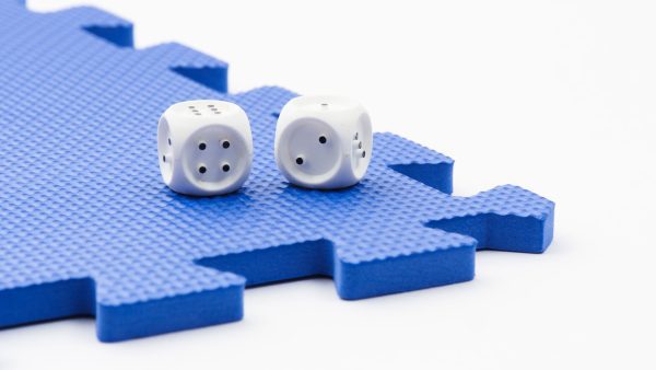 A pair of dice sitting on a blue foam square