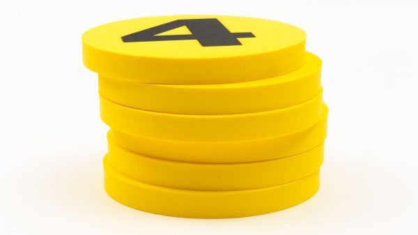 A stack of yellow foam dots. The top dot has a black number 4 printed on top.