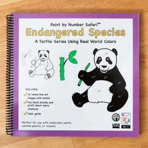 A spiral bound braille book with an illustration of a panda on the cover. It's holding a bamboo shoot. At the top it says "Paint by Numbers Endangered Species"