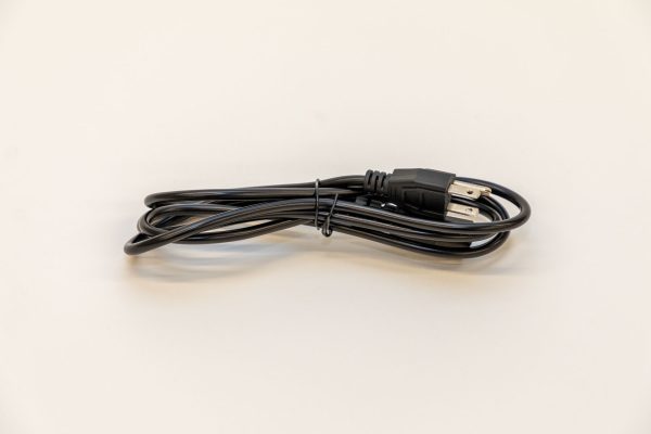 The black PageBlaster power cord wrapped up sitting on a white background.