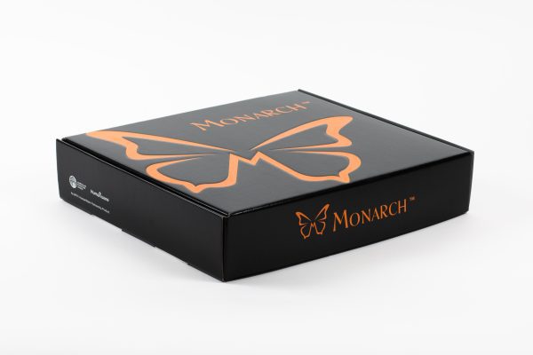 The Monarch box on a white background. On top is the Monarch logo, an orange graphic butterfly next to the word "MONARCH." On the left side of the box, the APH and HumanWare logos are visible. The Monarch logo appears again on the front edge.