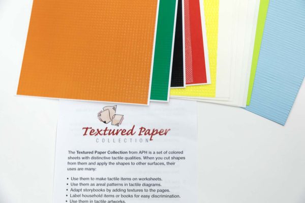 A stack of multi-colored textured paper fanned out with the textured paper insert positioned underneath.