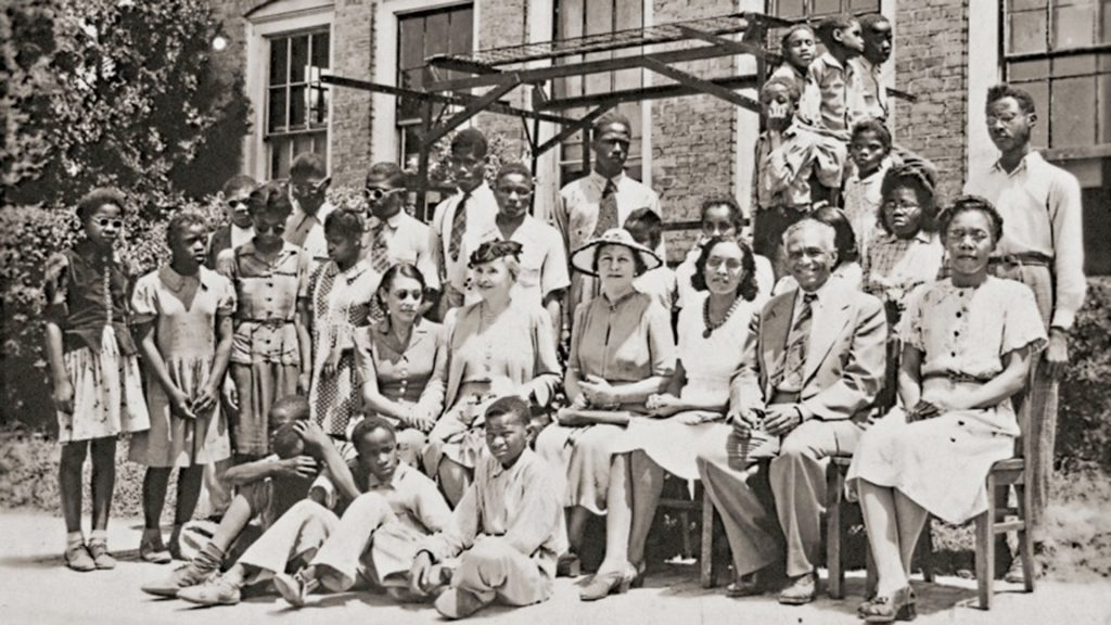 Helen Keller sits among a group of students and teachers outside of Piney Woods School in 1945.