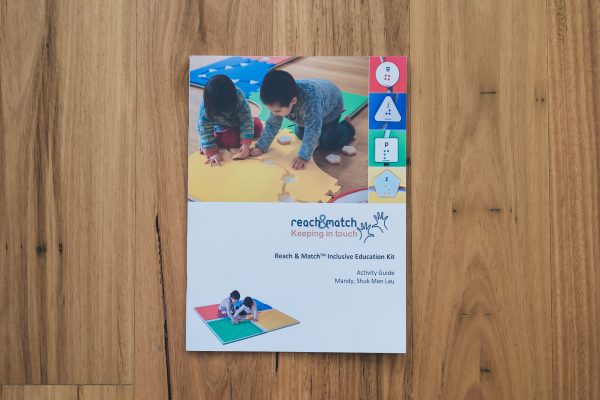 The Reach and Match Light print guidebook laid on a wooden floor.