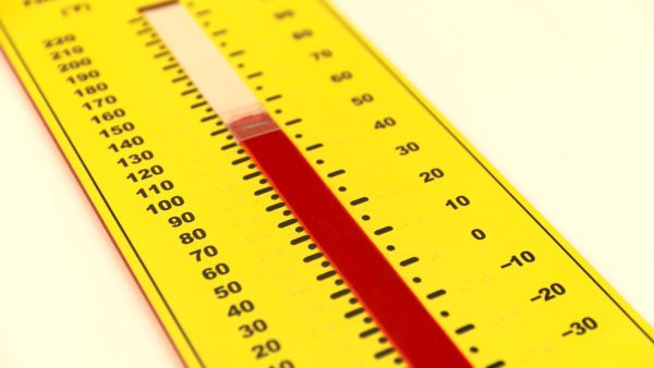 A close up of the yellow Tactile Demonstration Thermometer on a white background. In the center of the thermometer is a red velvet "mercury column" that can be adjusted with a clear easy-grip indicator. The edges of the photo are blurred with a crisp focus in the center of the thermometer.