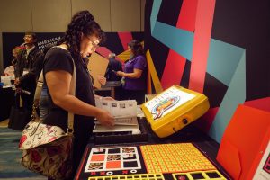 A woman leans over a table looking at APH's LED light box.