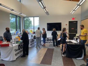 Event attendees stand in front of tables with the Dot Experience table cloths