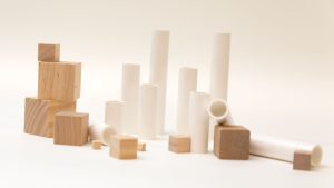 An assortment of white plastic cylinders and wooden cubes in varying sizes