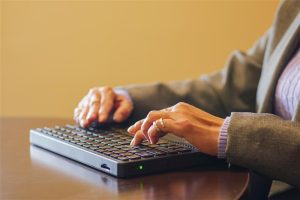 Woman typing on a braille keyboard