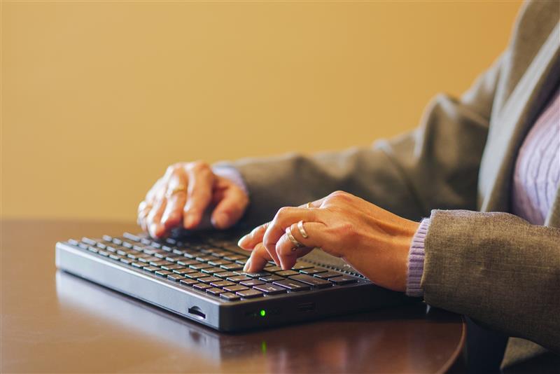 Woman typing on a braille keyboard