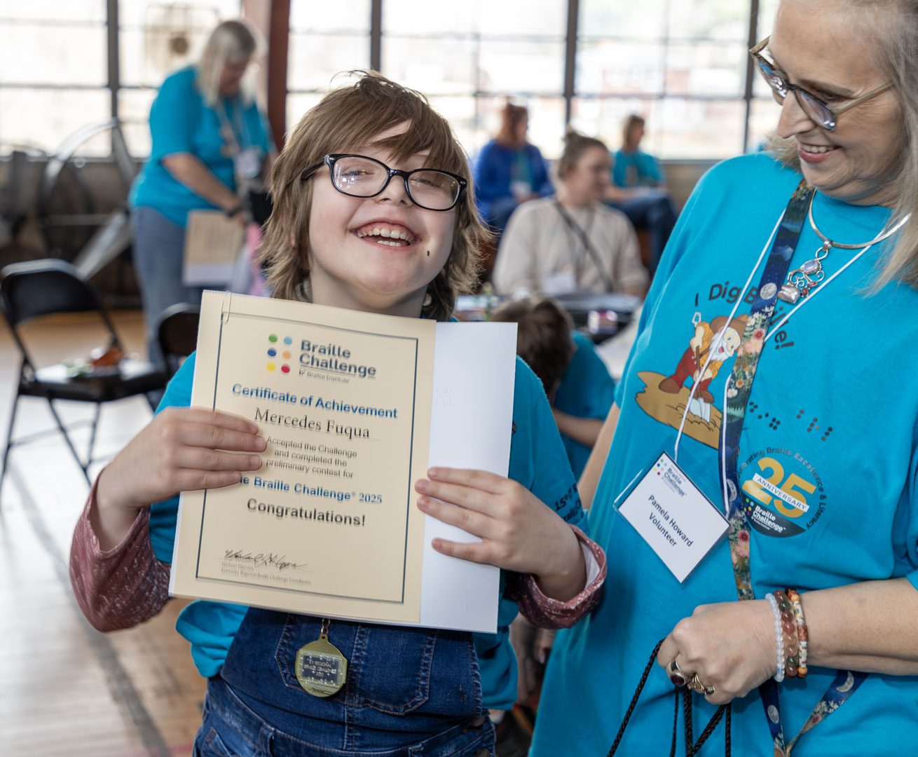 A young girl with glasses smiles into the camera, holding a certificate for her completion of the braille challenge.