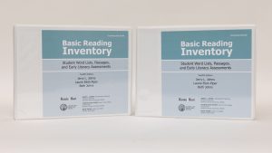 Two three-ring Basic Reading Inventory binders standing on a white background. The blue covers are labeled 